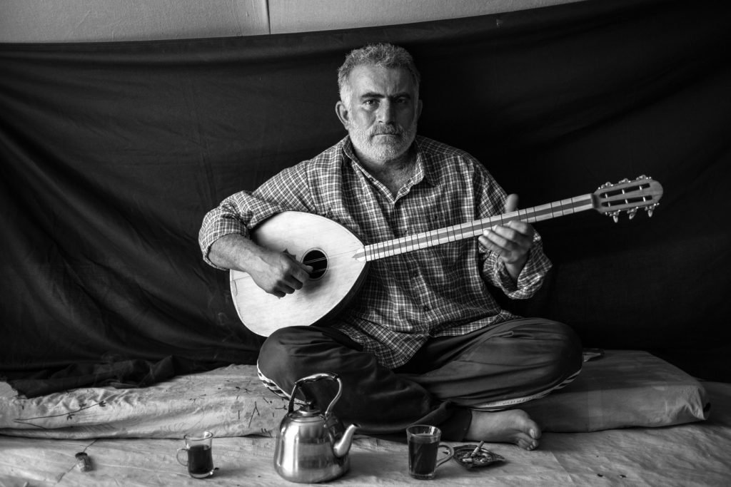 Nasraldien Mohammed Ibrahim (Omar), 37 años, en su tienda de campaña en el campamento de refugiados de Domiz en Kurdistán, Iraq (16 de noviembre de 2012). Omar huyó de Damasco con su esposa y sus dos hijos la noche en que sus vecinos fueron asesinados. «Entraron en la casa y descuartizaron a mi vecino y a sus dos hijos. Arrastraron los cuerpos hasta la calle, donde los encontramos por la mañana». Lo más importante que Omar se llevó es su buzuq, el instrumento que muestra en esta fotografía. «Tocar me llena de un sentimiento de nostalgia y me recuerda a mi tierra natal. Por un momento, alivia un poco mis penas».Nasraldien *Unsure of spelling. Apparently it is a Greek instrument and the name is pronounced "bizz-uk" Note: The subject's actual name, place of origin and current location are given in this photo caption. Please ensure that all are changed as required for protection purposes. Note: The subject agreed to be photographed with his face displayed openly. He said that he can be contacted by UNHCR if they wish to confirm this. Arriba, Malian refugee Mamma Wallet Bona, 40, center, and her children, pose for a portrait inside their shelter at Damba refugee camp in Burkina Faso on March 11, 2013. Agade’s wife Mamma brought the family tea set. “The life of the Tuareg is tea,” she says. “It gives us energy, even when there is no food.” During the journey, she kept it next to her in a small sack, slung over the back of the donkey she and three of her children rode to escape. Drinking tea is the first thing that Mamma does each morning, a ritual that is repeated throughout the day. “Tea is the tradition of our ancestors. If we don’t follow that tradition, we are no longer Tuareg.” UNHCR/B. Sokol